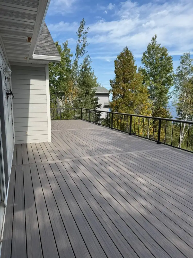 Upper composite deck with black railings overlooking the trees