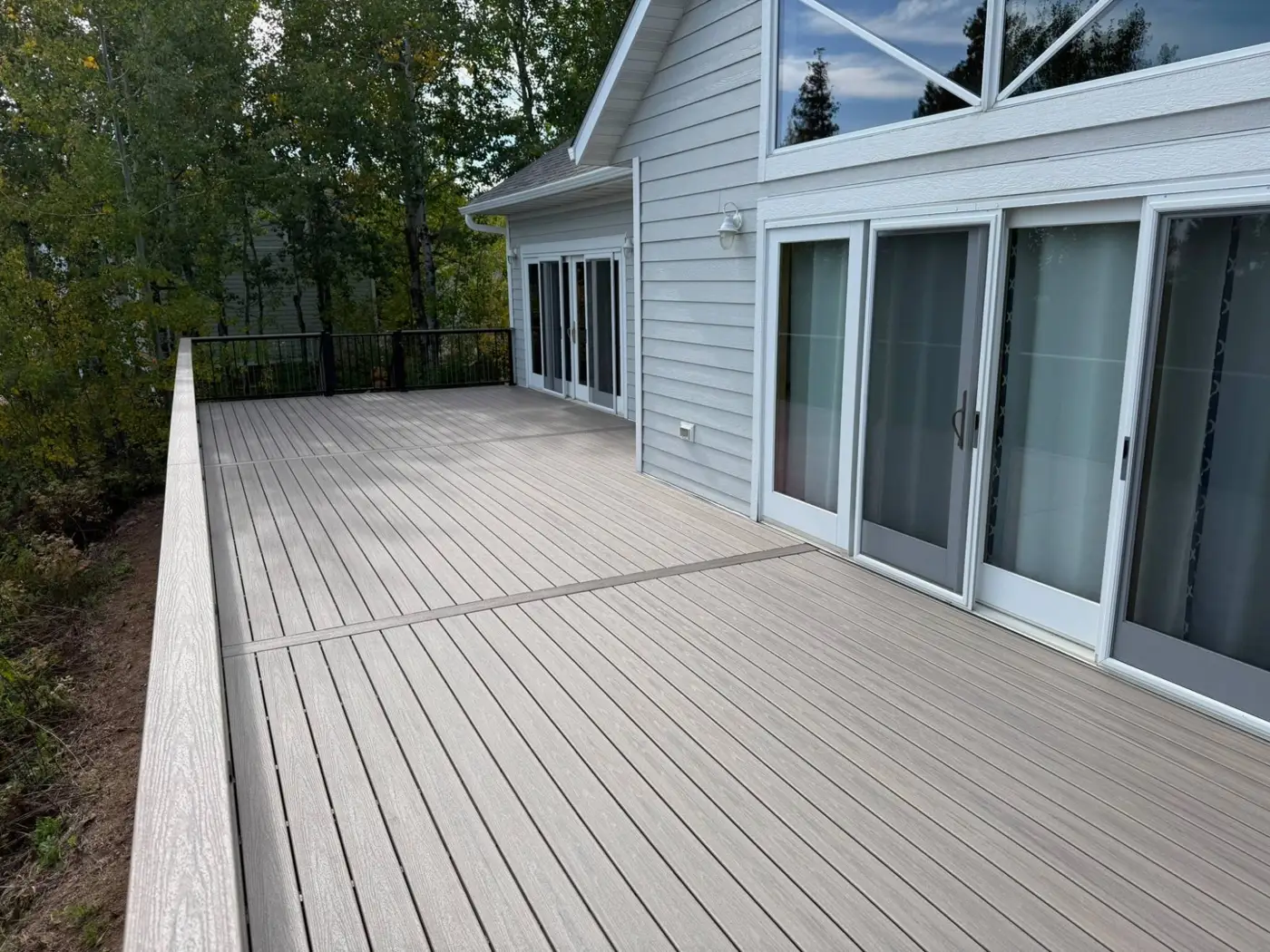 Long composite deck with picture-frame border along sliding patio doors