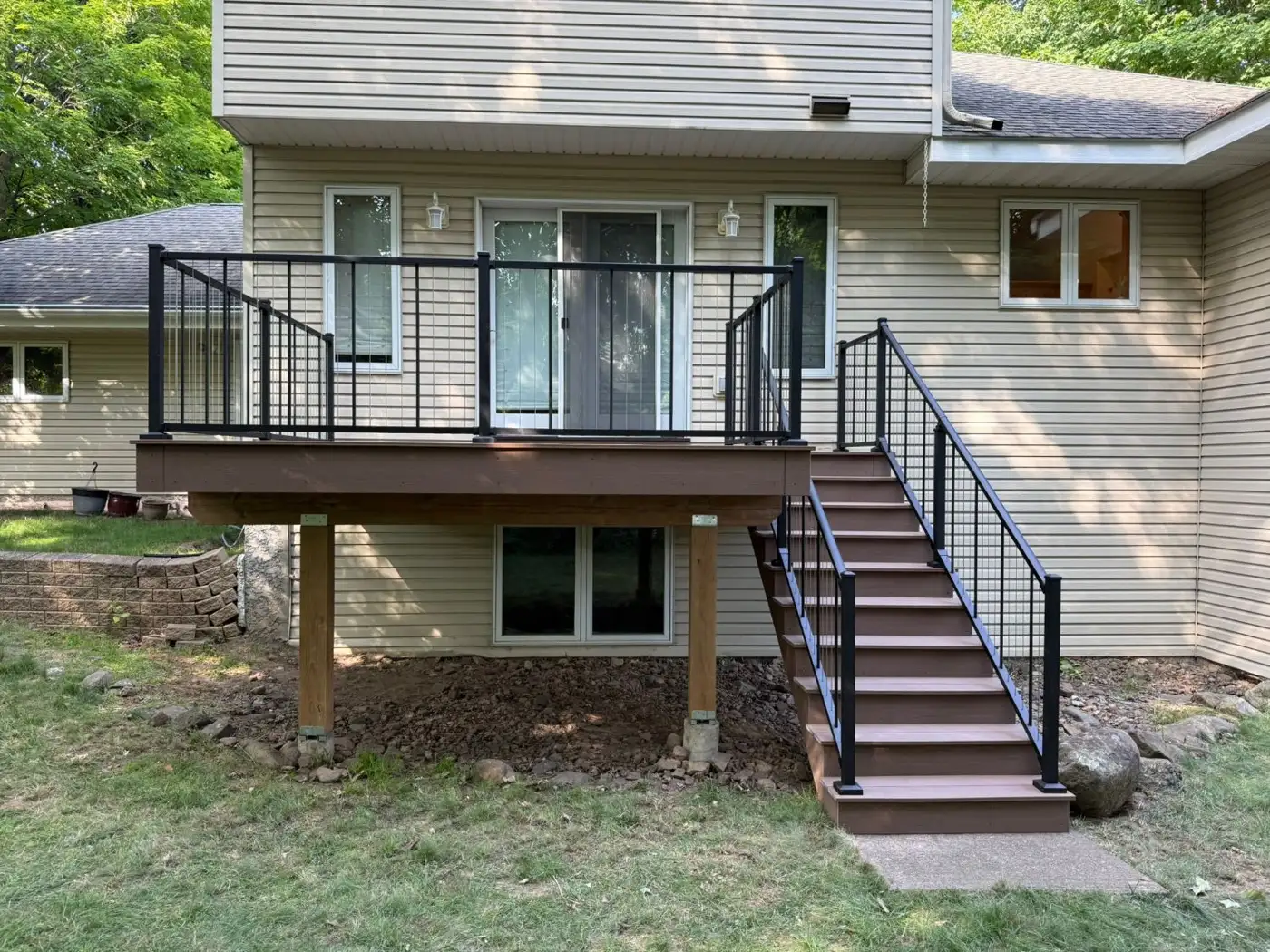Elevated composite deck with black railings, stairs and timber posts