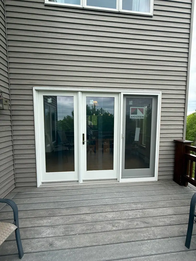 New white hinged patio door with a sliding screen, installed onto a deck
